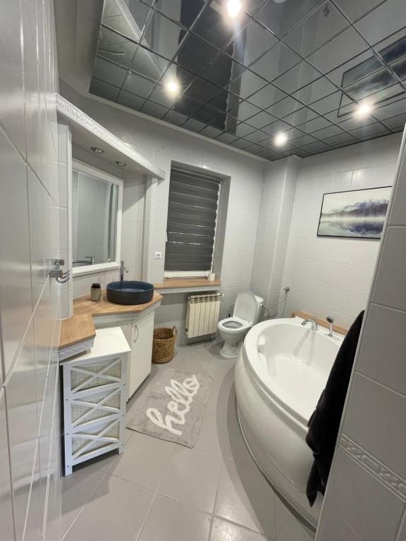 a bathroom with a tub and a toilet and a sink at Zarzecze 27A in Augustów