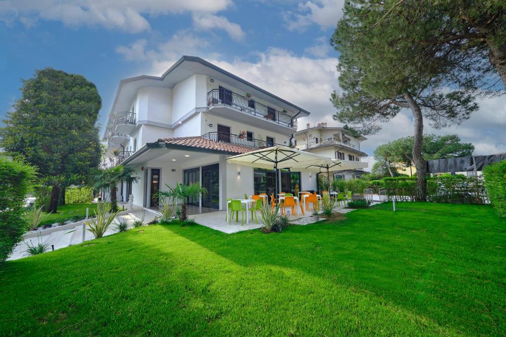 a white house with a lawn in front of it at HOTEL VITTORIA in Sirmione