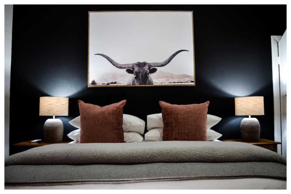 a bedroom with a bed with a picture of a bull at @Mango's in Beaufort West