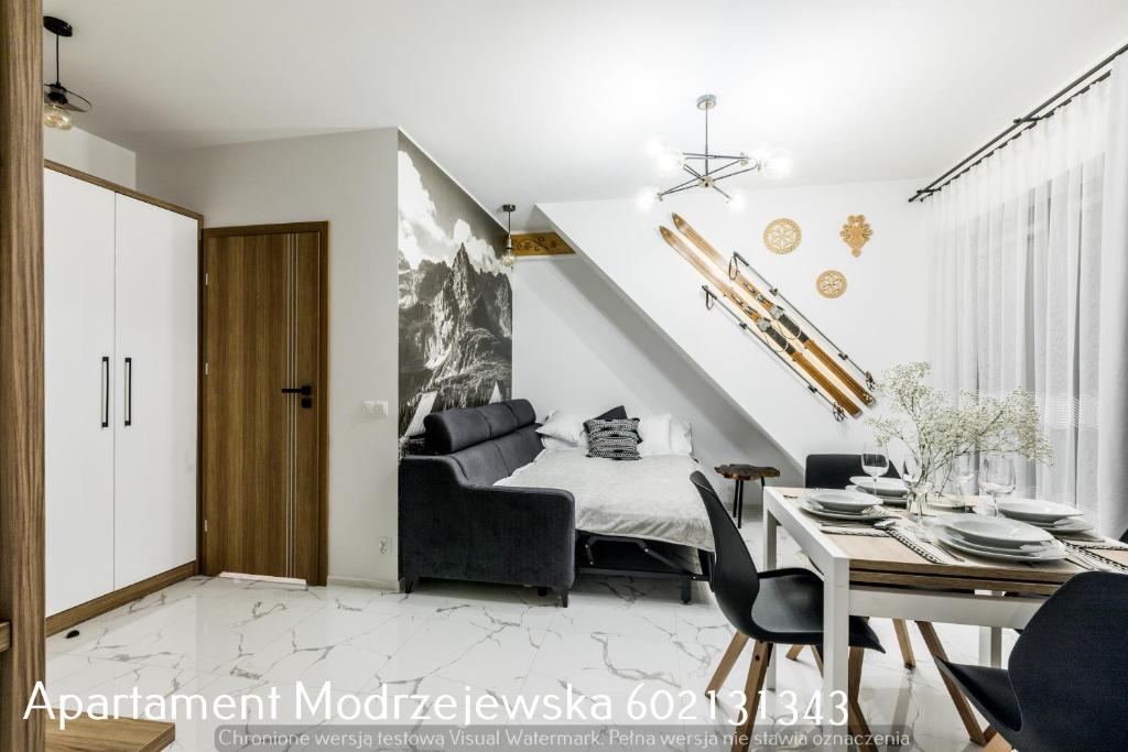 una camera con un letto e un tavolo con sedie di Apartament Modrzejewska a Zakopane