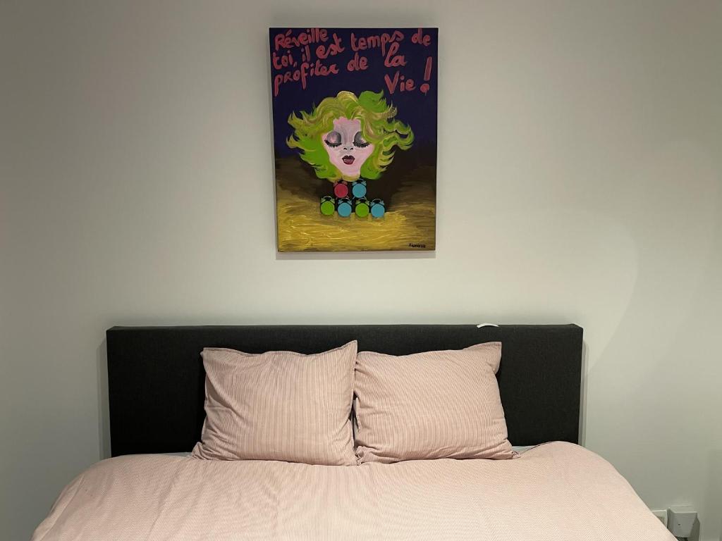 a bedroom with a bed with a painting on the wall at Studio Just For 2 in Ostend