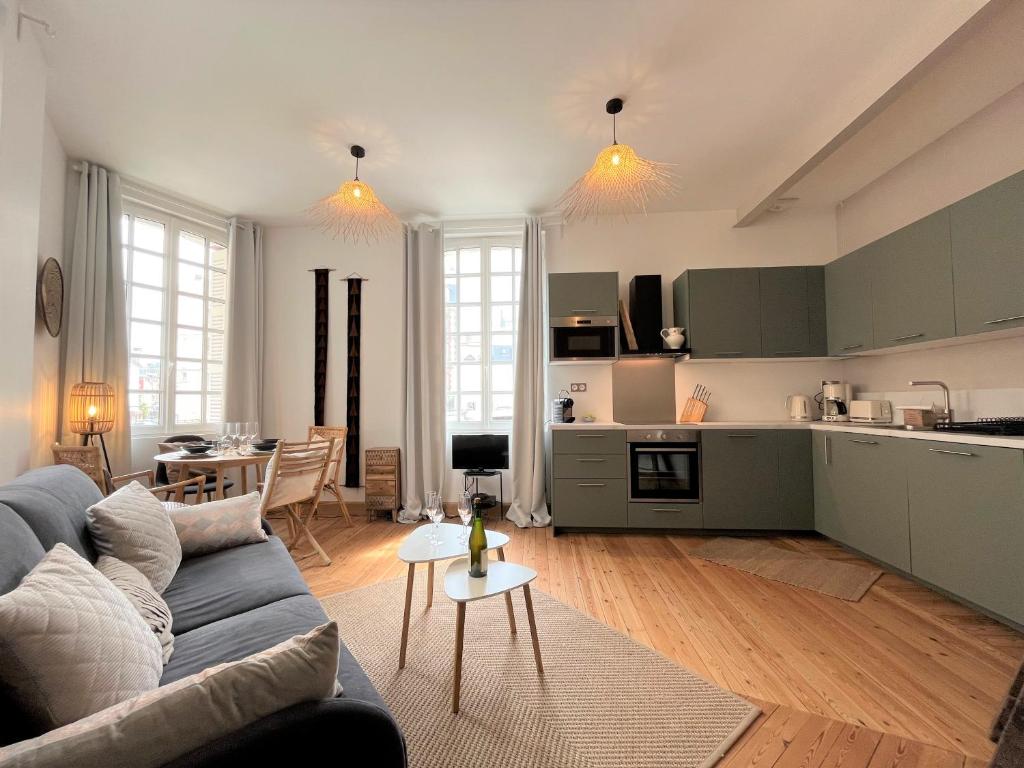 uma sala de estar com um sofá e uma cozinha em L emeraude - Trouville em Trouville-sur-Mer