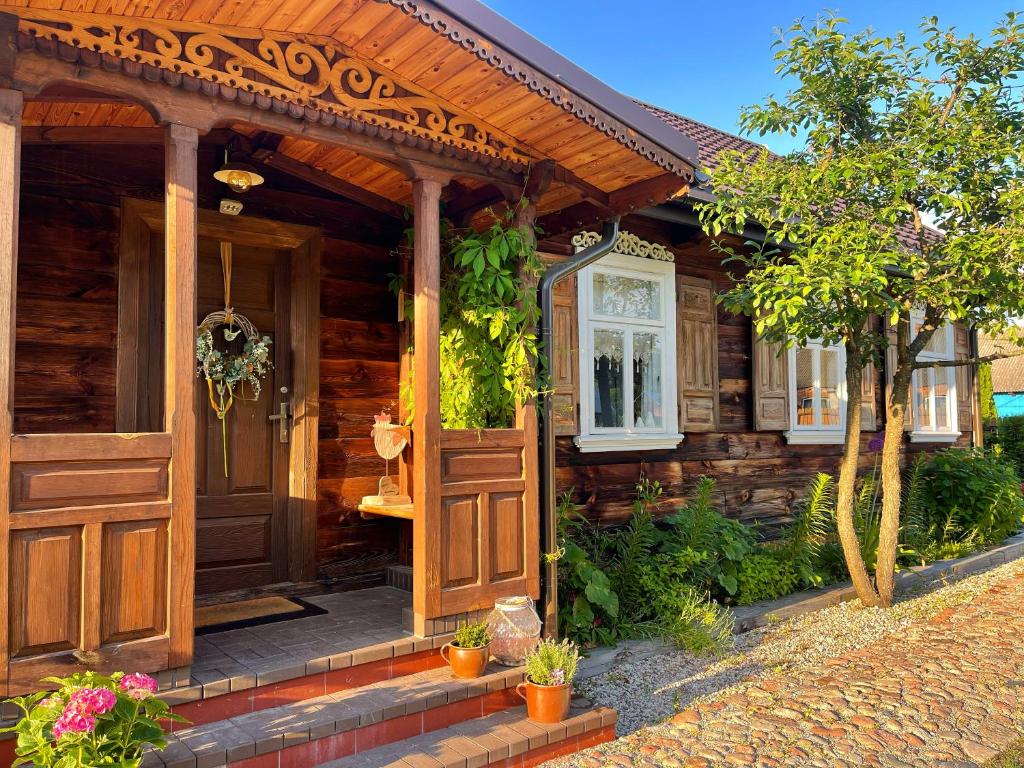 a house with a wooden door and a porch at INNA BAJKA in Nowy Berezów