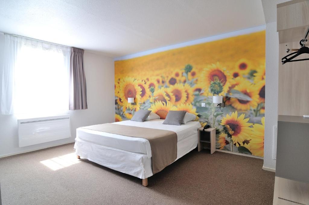 una camera con un letto e un dipinto di fiori di Relais Fasthotel Port Lauragais ad Avignonet-de-Lauragais