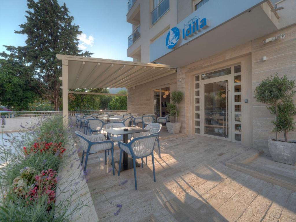 een patio met tafels en stoelen voor een gebouw bij Hotel Idila Budva in Budva