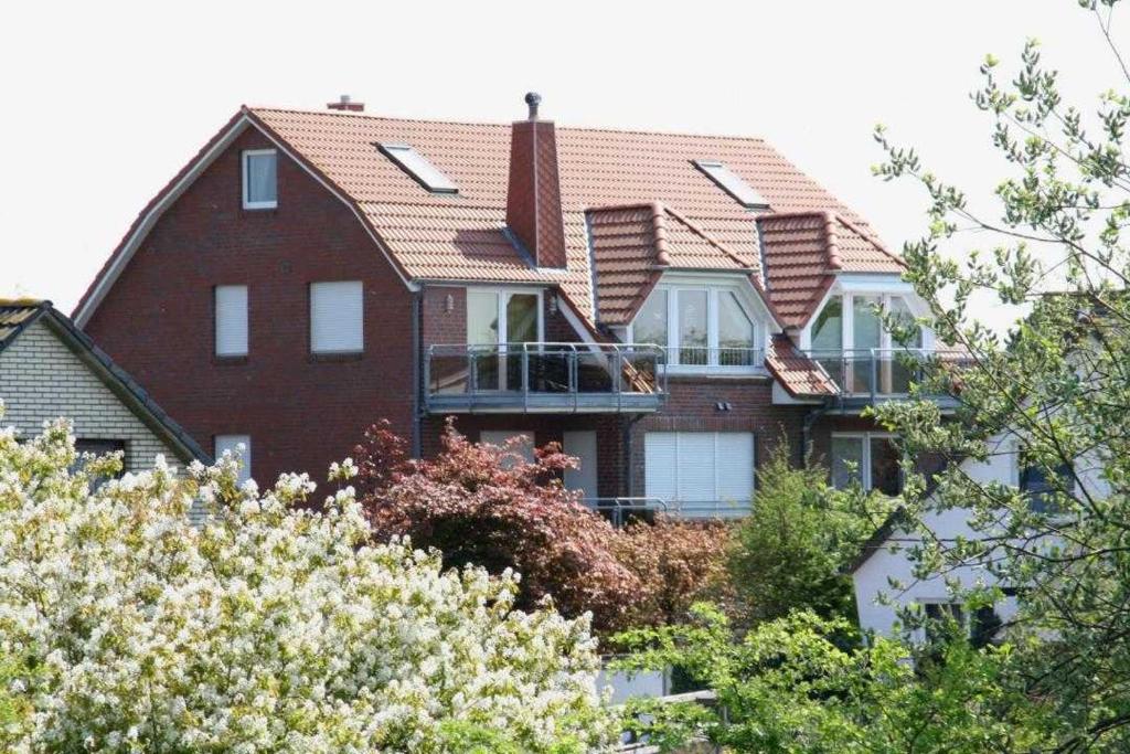 een groot rood bakstenen huis met ramen en bomen bij Residenz Trossenstek in Cuxhaven