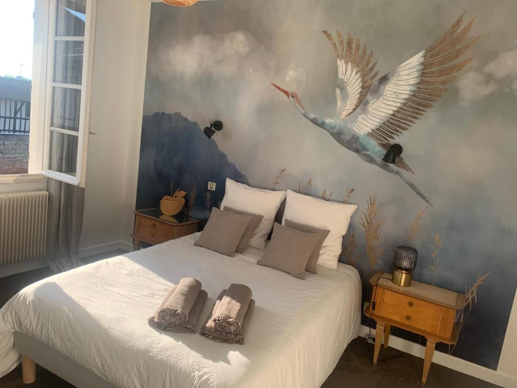 a bedroom with a bed with birds on the wall at Gite les Zozios du lac du Der in Hauteville