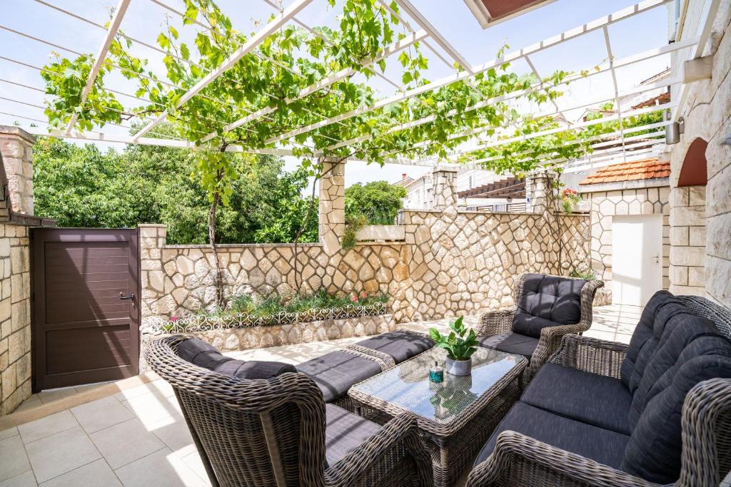 un patio con muebles de mimbre y techo de cristal en Holiday Home King, en Dubrovnik