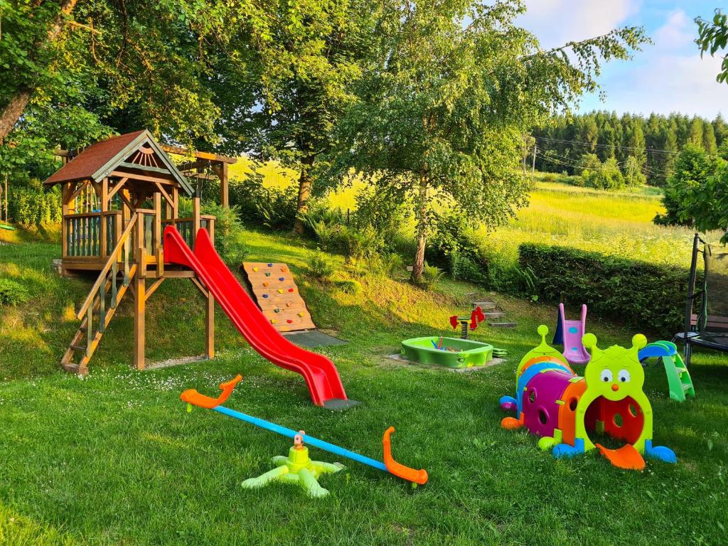 a park with a playground with a slide and play equipment at Domki Pod Horbem in Polańczyk