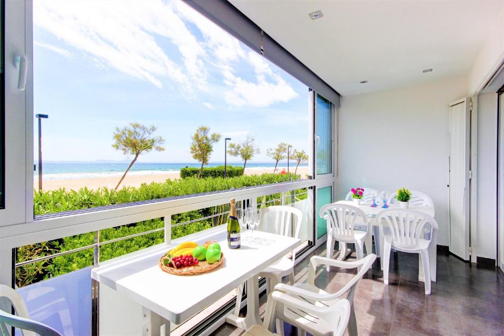 a dining room with a view of the beach at Residence de la Plage Roses - Immo Barneda in Roses