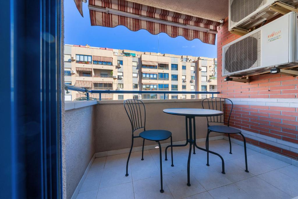 Duas cadeiras e uma mesa numa varanda com um edifício em Holidays2Malaga Ayala 450 mts from beach & Terrace em Málaga
