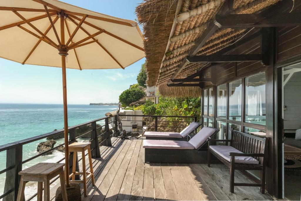 روما إليزابيث وروما جانيك في أُلُواتو: بلكونه فيها كراسي ومظله والمحيط