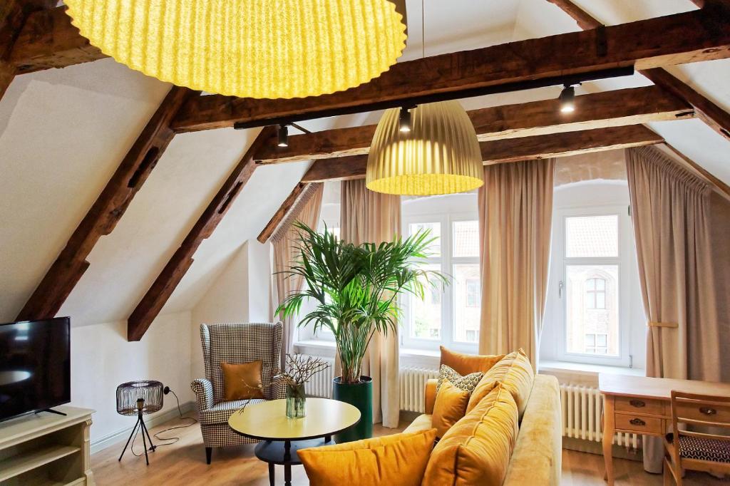 a living room with a yellow couch and a table at Apartamenty pocztowe in Toruń