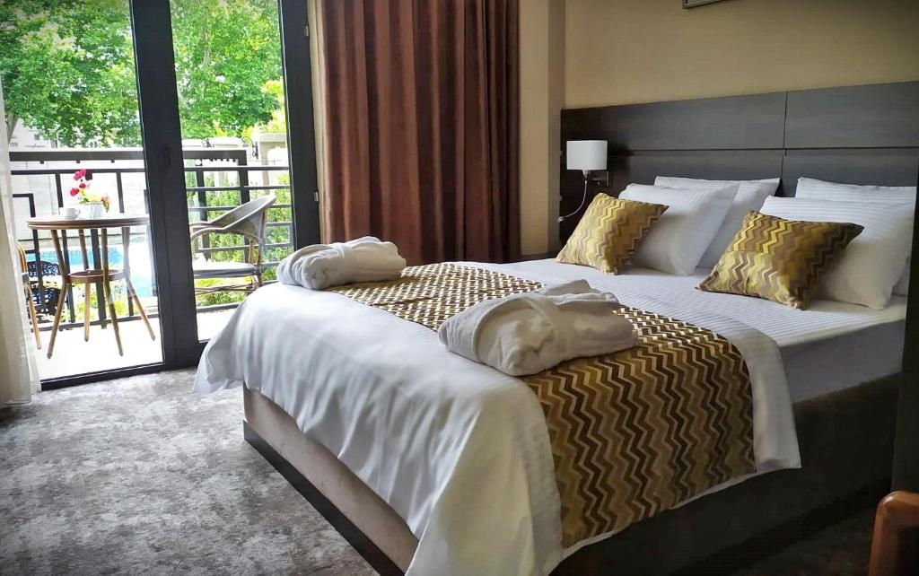 Postel nebo postele na pokoji v ubytování Vinum Hotel