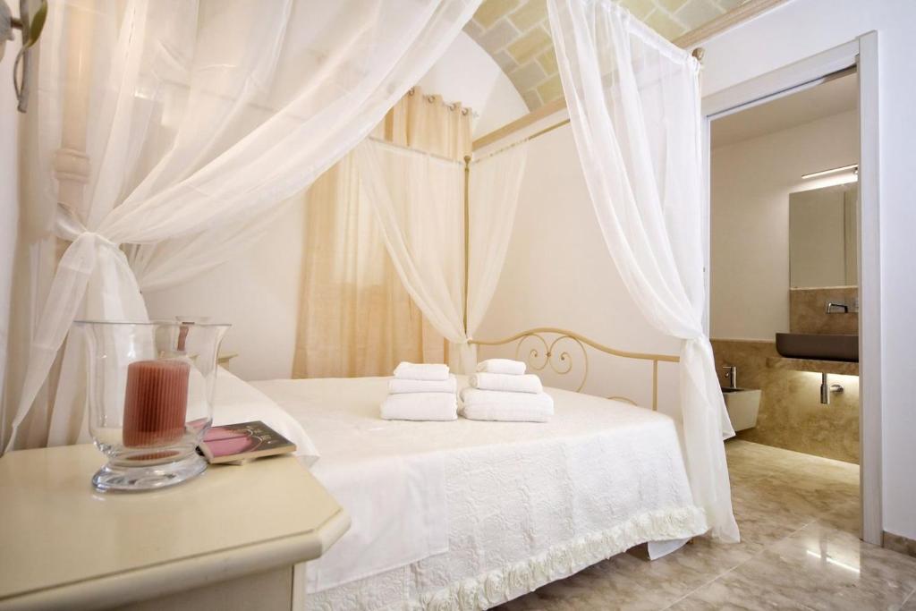 una camera da letto bianca con un letto e asciugamani di AFFITTACAMERE I PACIORRA a Favignana