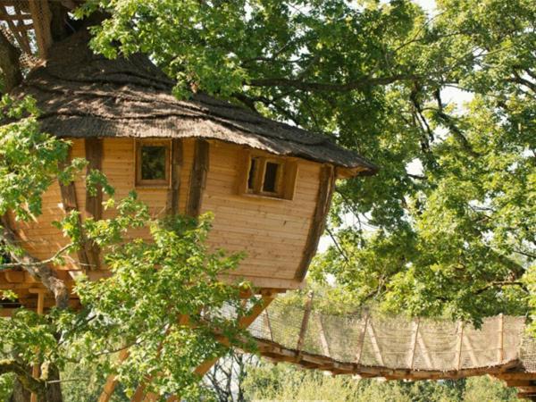 Cabane Perchée dans les Arbres في Saint-Hilaire-en-Morvan: بيت شجرة وسط بعض الاشجار