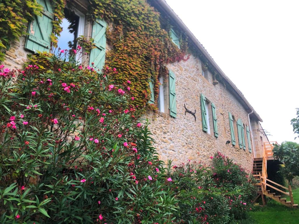 a brick building with pink flowers in front of it at Residence La Borde in Plavilla