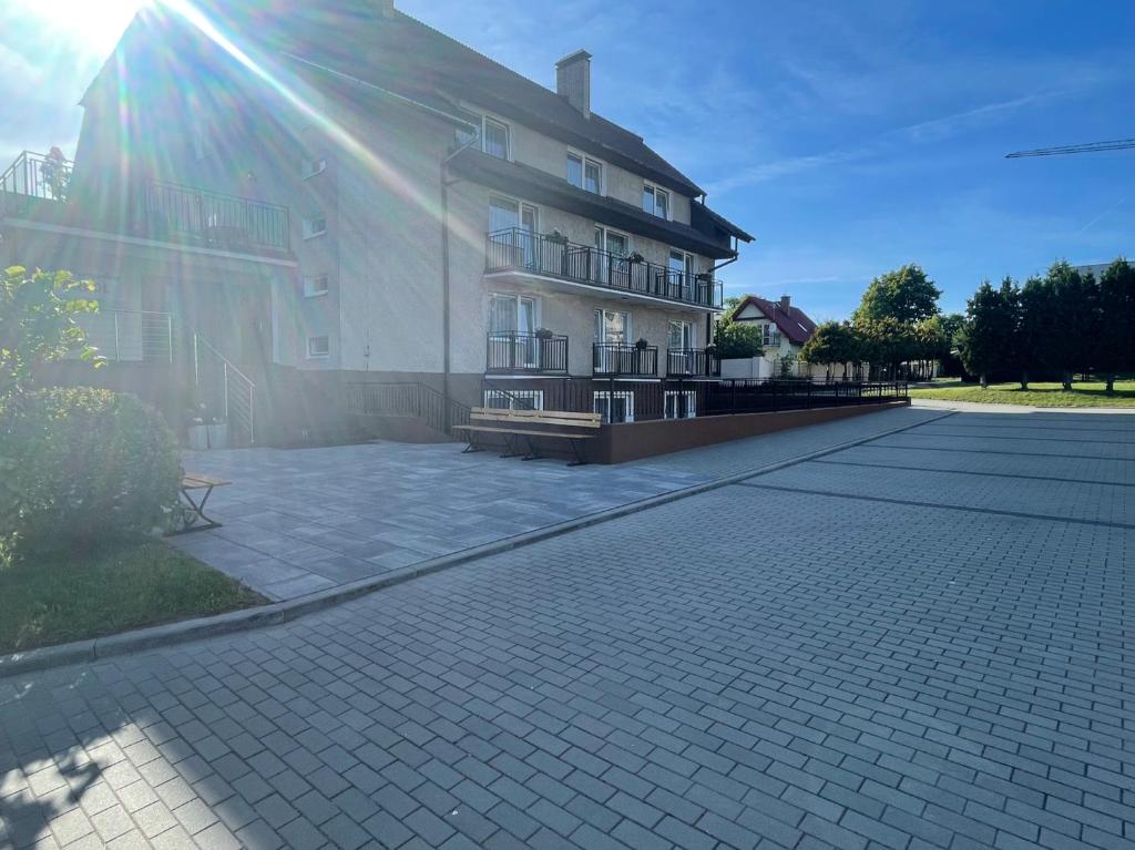 a building with the sun shining on the side of it at Dom Wypoczynkowy Arpol in Ustronie Morskie