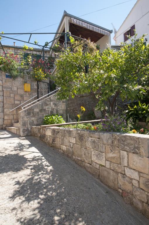 a stone retaining wall with flowers and plants at Apartments Gorana in Splitska