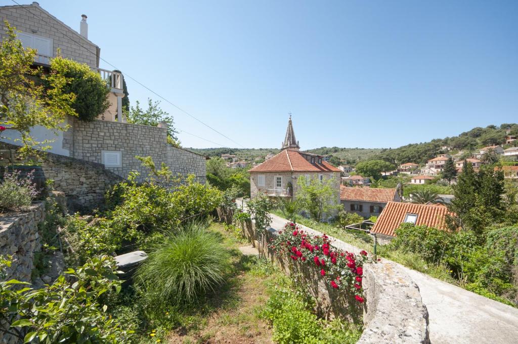 a view of a town with flowers on a hill at Apartments Gorana in Splitska