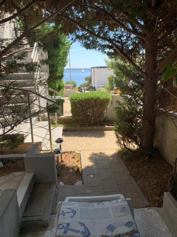 Blick auf eine Terrasse mit einem Baum und das Meer in der Unterkunft Mandre - Dalmacija in Mandre