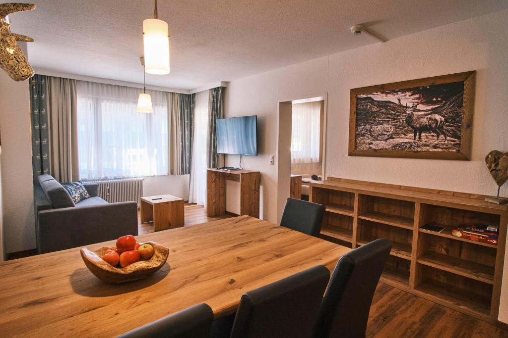 un soggiorno con tavolo in legno e cesto di frutta di Pension Rainer a Ellmau