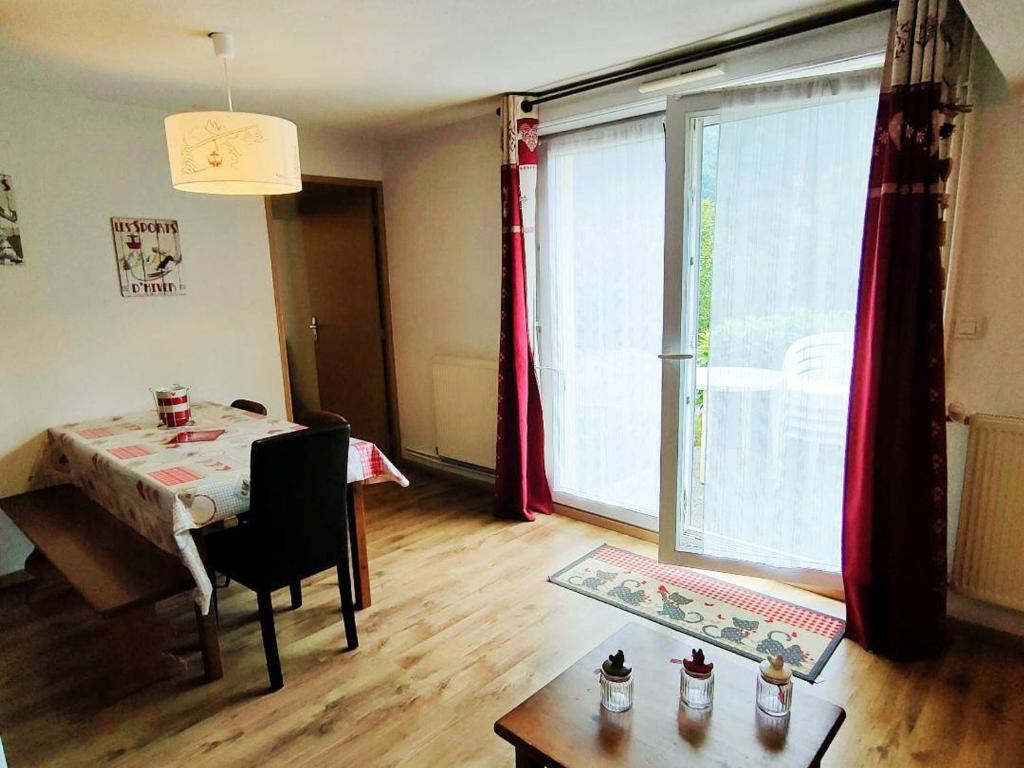 un salon avec une table et une grande fenêtre dans l'établissement Appartement T2bis à Cauterets, 6 pers, piscine, à 250m des télécabines, parking privé - FR-1-234-182, à Cauterets