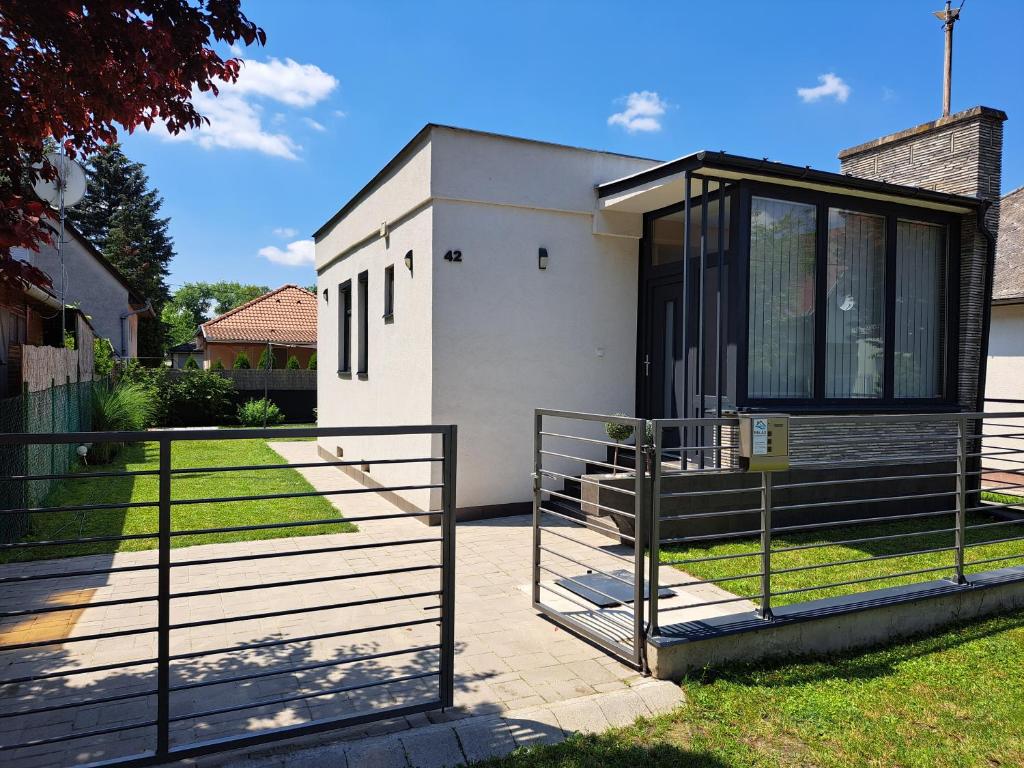 una casa con una puerta y una valla en Relax Vendégház, en Dunapataj