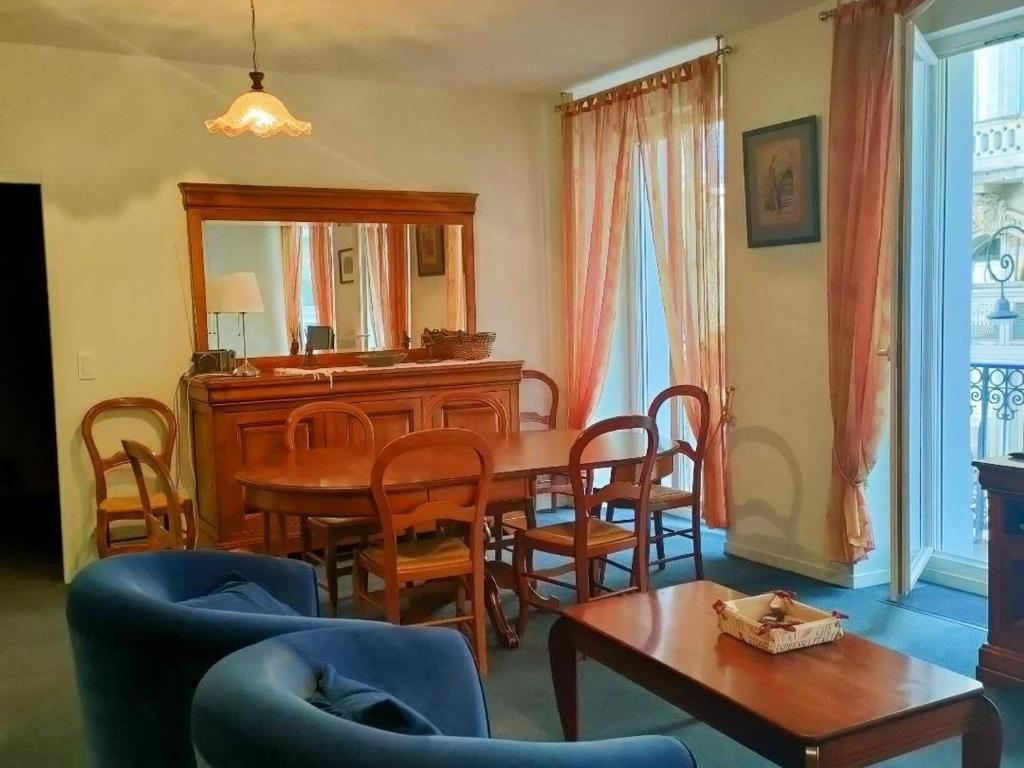 une salle à manger avec une table, des chaises et un miroir dans l'établissement Spacieux Appartement 8 Pers. avec Balcons, 2 Salles de Bain, Parking Gratuit - Cauterets - FR-1-234-165, à Cauterets