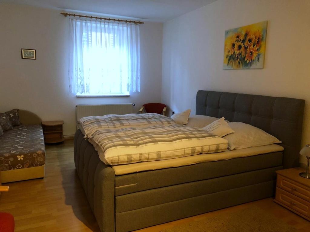 1 dormitorio con 1 cama en una habitación con ventana en Ferienwohnung Buschbeck, en Marienberg
