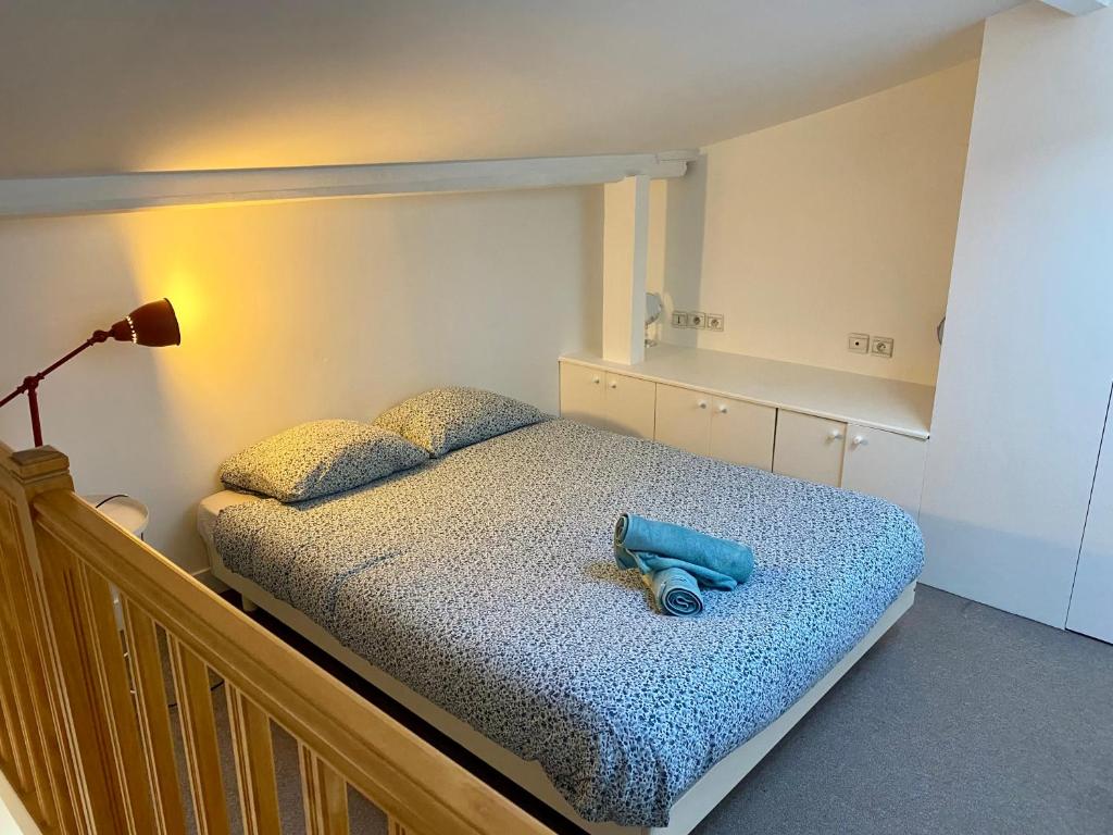 ein Schlafzimmer mit einem Bett mit blauem Objekt darauf in der Unterkunft Home Sweet Home Champs Elysées Niel in Paris