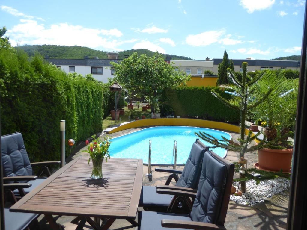a patio with a table and chairs and a pool at Ferienwohnung Hagebuttenweg in Thale