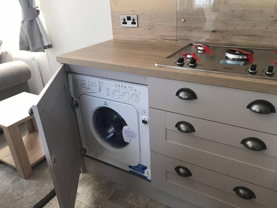a washer and dryer under a counter in a kitchen at Beautiful holiday 3 bed Home Camber-sands in Camber