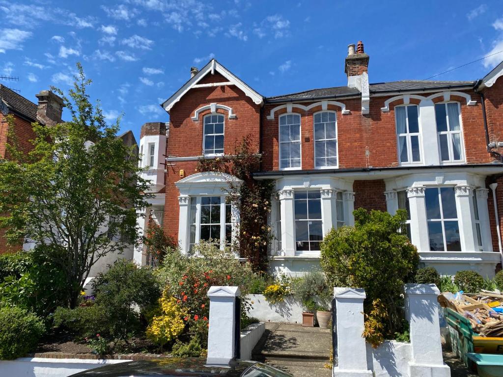 uma grande casa de tijolos vermelhos com janelas brancas em Anne’s House em Hastings