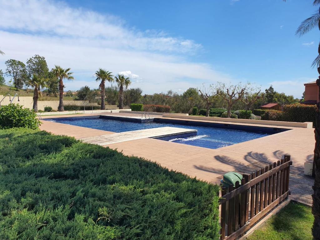 a swimming pool in a yard with a wooden fence at Casa unifamiliar Bonmont - Miami Playa / Mont Roig del Camp in Bonmont Terres Noves