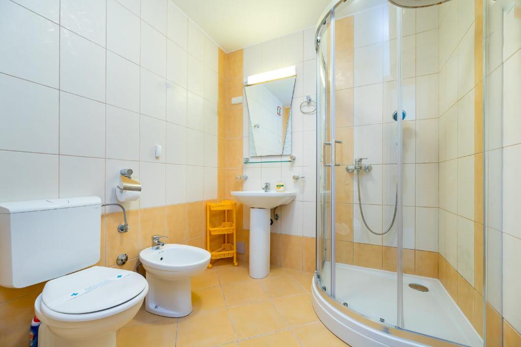 łazienka z toaletą, umywalką i prysznicem w obiekcie Apartments Melania & Antonia w Bašce