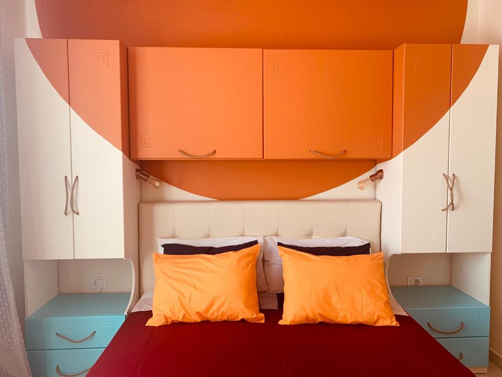 a bedroom with a bed with two orange pillows at Perfect location, nature and sea - SELF check-in in Golem