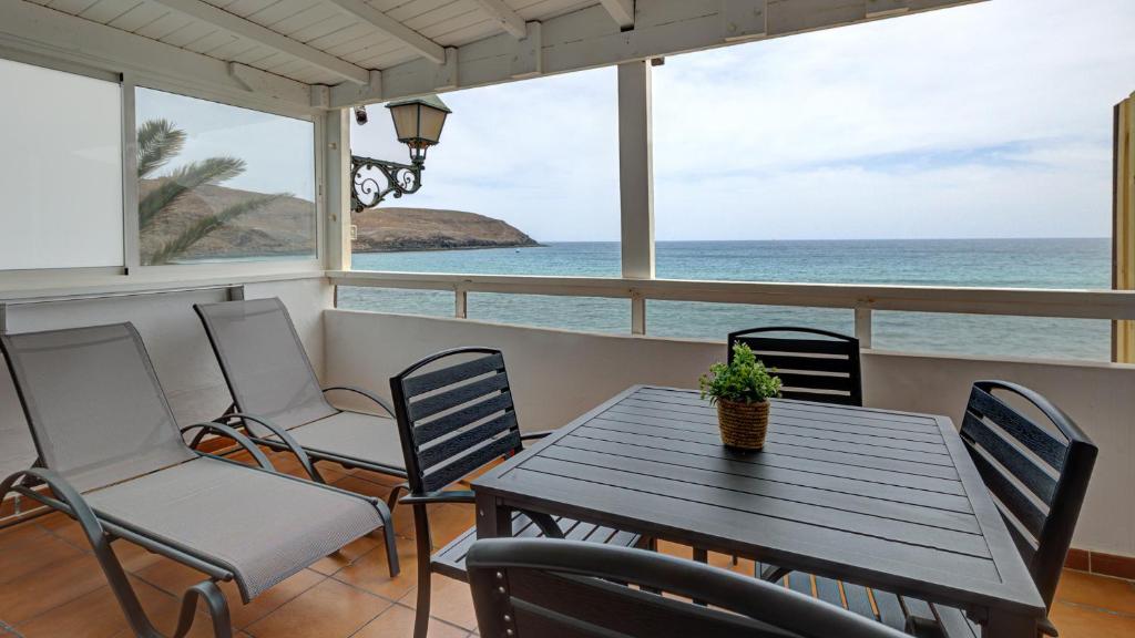 un tavolo e sedie su un balcone con vista sull'oceano di POZO NEGRO SEA 2 a Pozo Negro