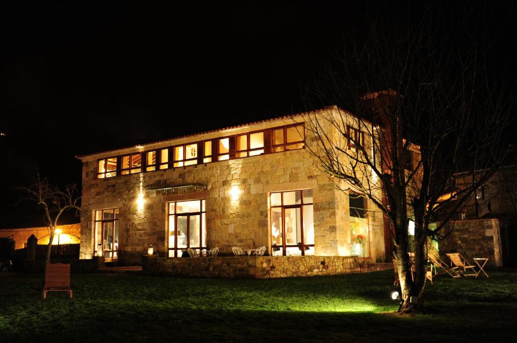 una gran casa de piedra por la noche con luces en LA POSADA, en Silió