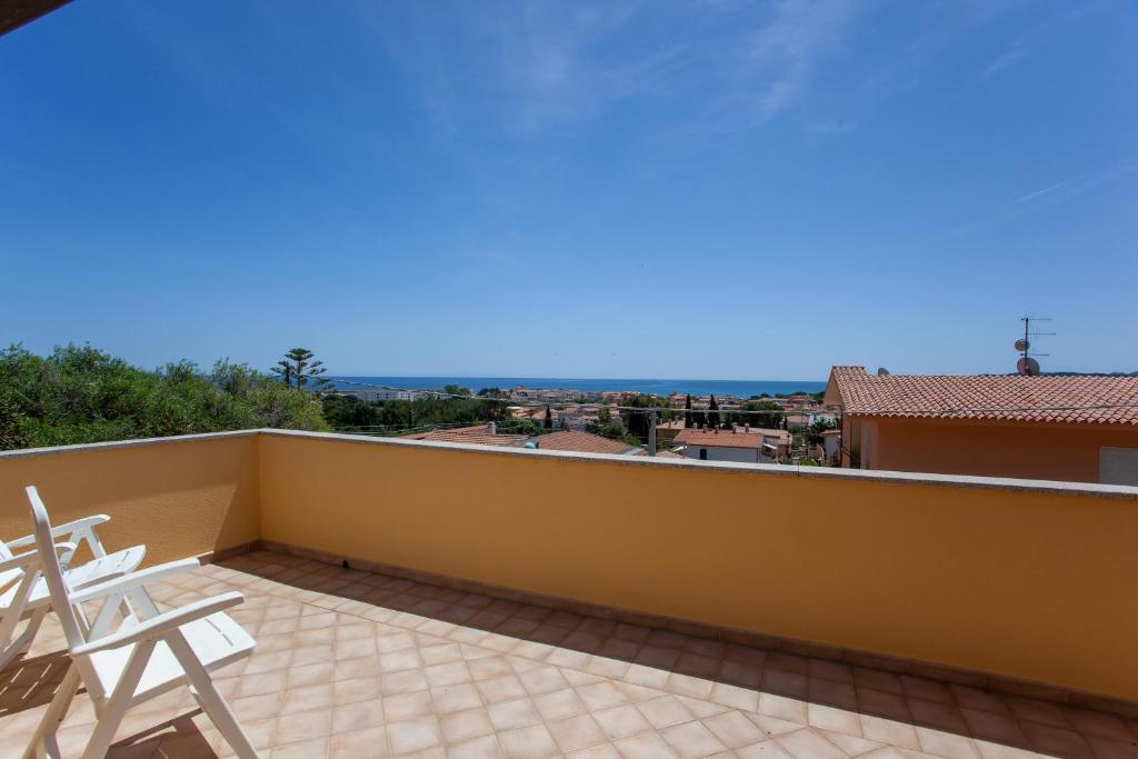 een balkon met stoelen en uitzicht op de oceaan bij La Caletta casa per vacanze in La Caletta