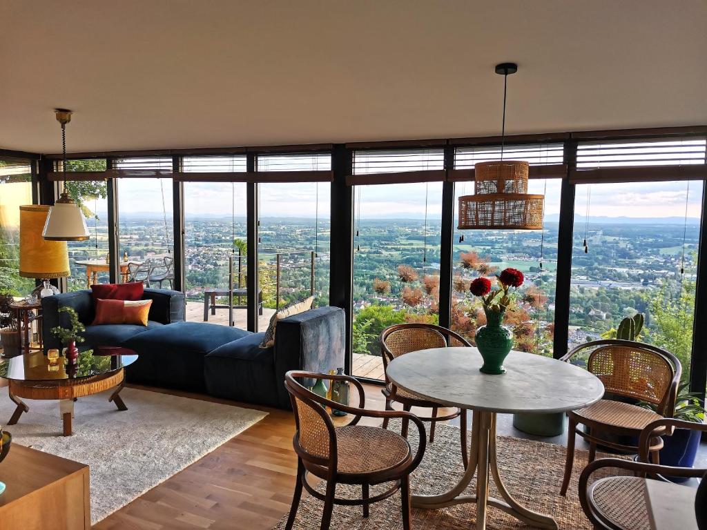 sala de estar con sofá y mesa con sillas en lodge-bélvédere sur les hauteurs de vichy en Vichy