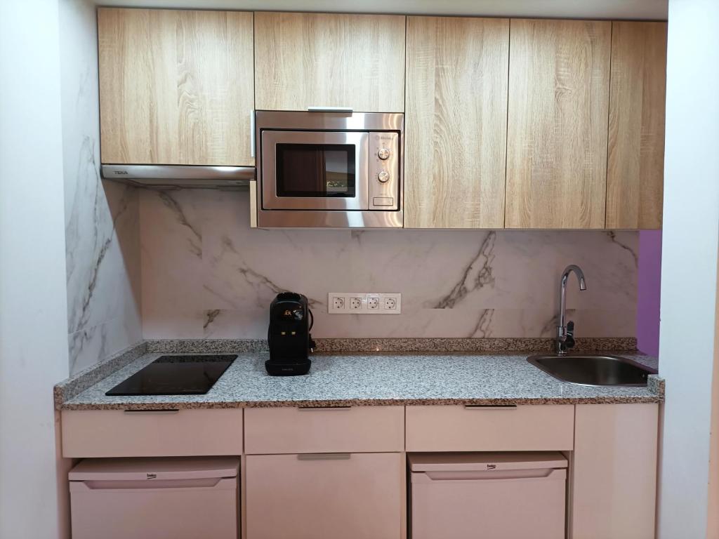 a kitchen with a sink and a microwave at Joan Miró Luxury Torremolinos in Torremolinos