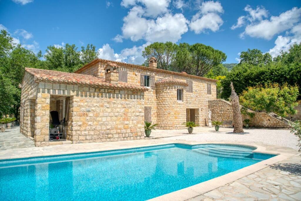 an external view of a stone house with a swimming pool at BASTIDE PROVENÇALE PROCHE CANNES in Peymeinade