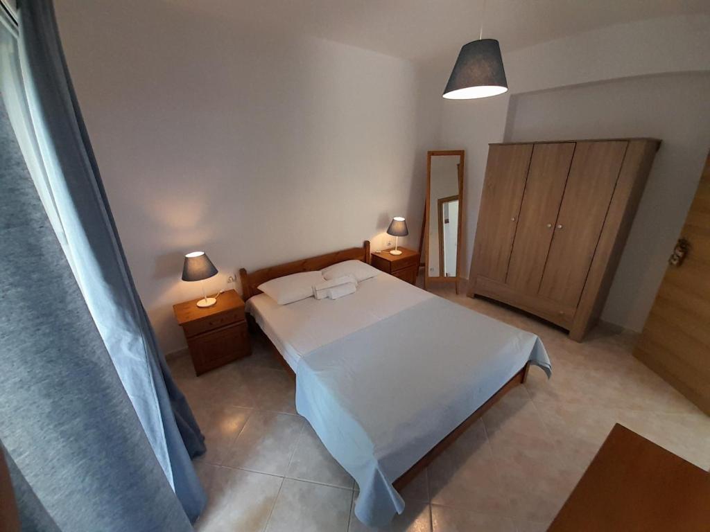 a bedroom with a white bed and two night stands at Χαλκιδική Κρυοπηγή in Kriopigi