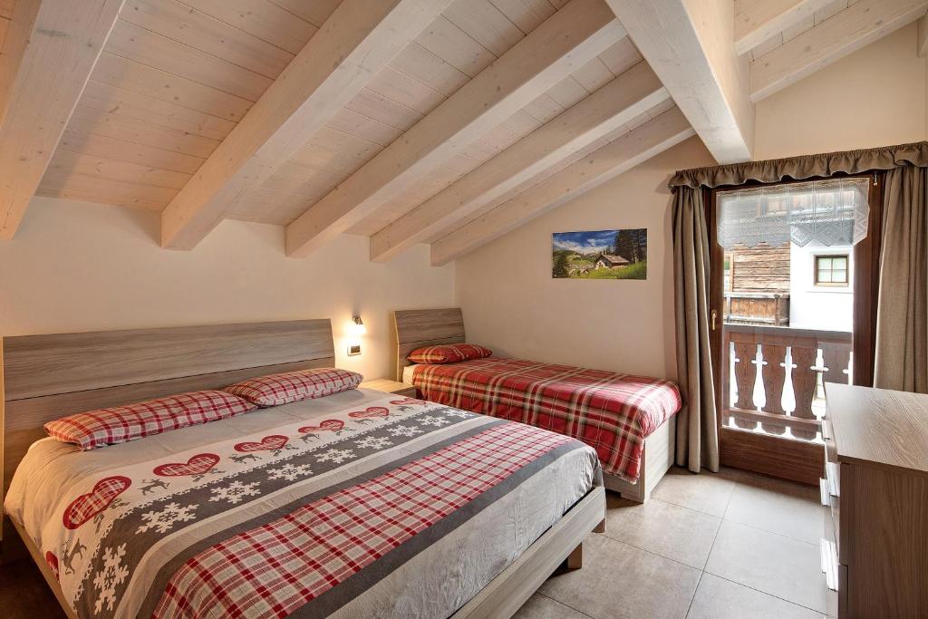 a bedroom with two beds and a window at Appartamenti Arcobaleno Arancione in Livigno