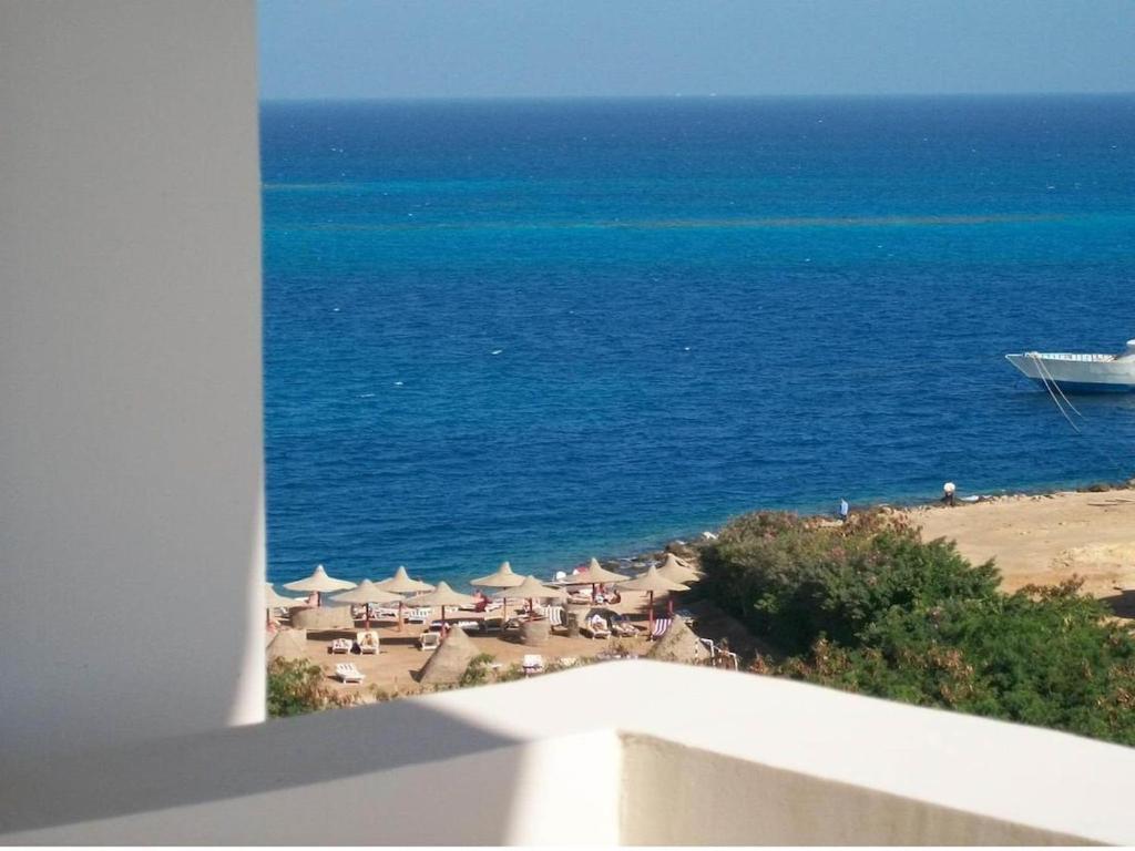 a view of a beach with a boat in the water at Hurghada Dreams in Hurghada