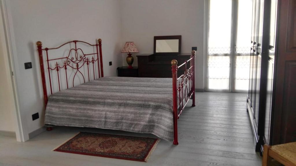 ein Schlafzimmer mit einem Bett mit einer gestreiften Decke und einem Fenster in der Unterkunft Casa Bonelli in Alba