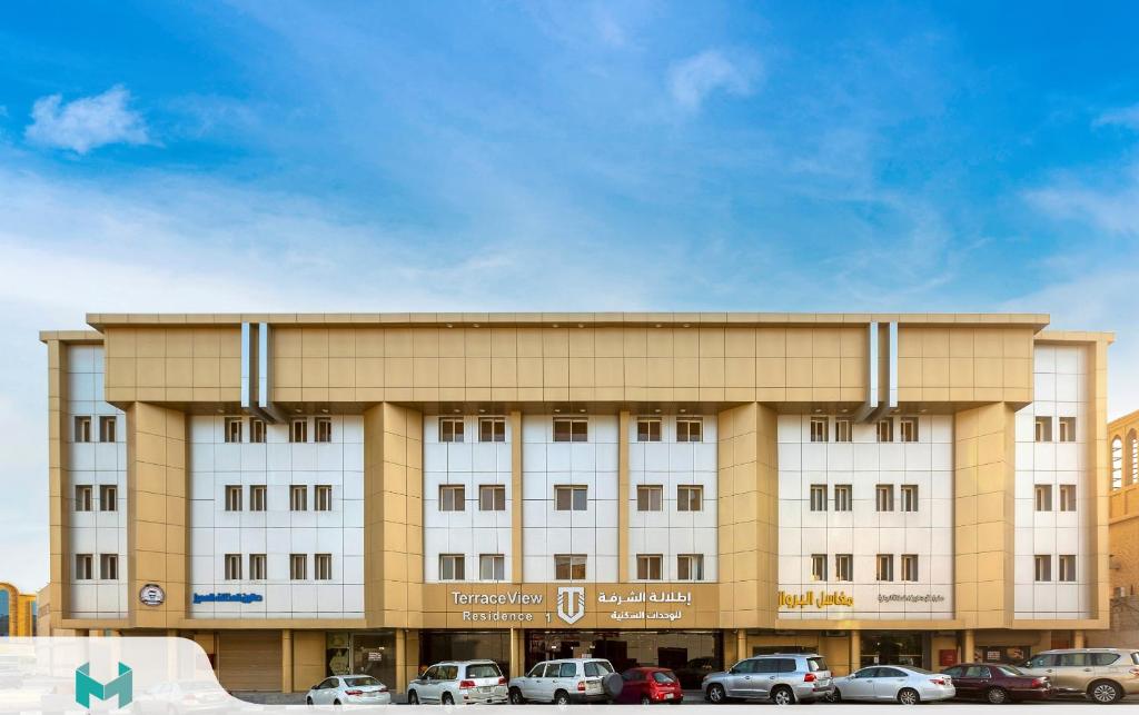 a large building with cars parked in front of it at اطلالة الشرفة 1-Terrace View 1 in Al Khobar