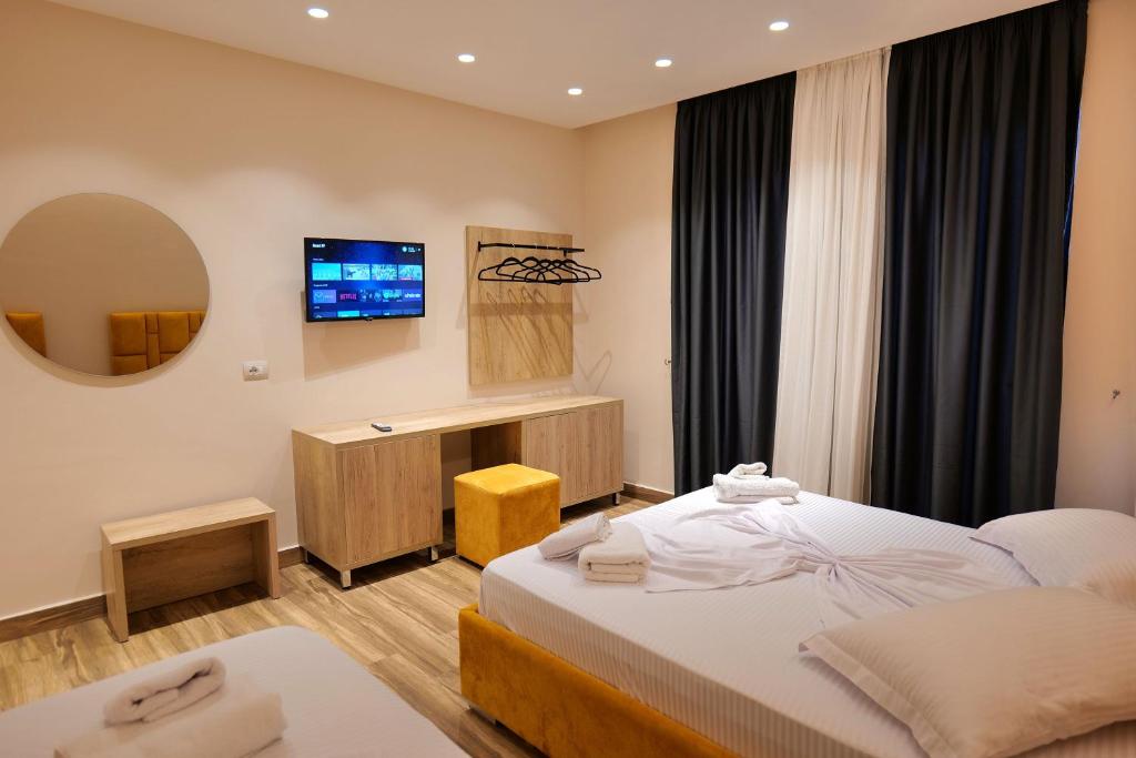 a hotel room with a bed and a television at Hotel Alexander in Ksamil