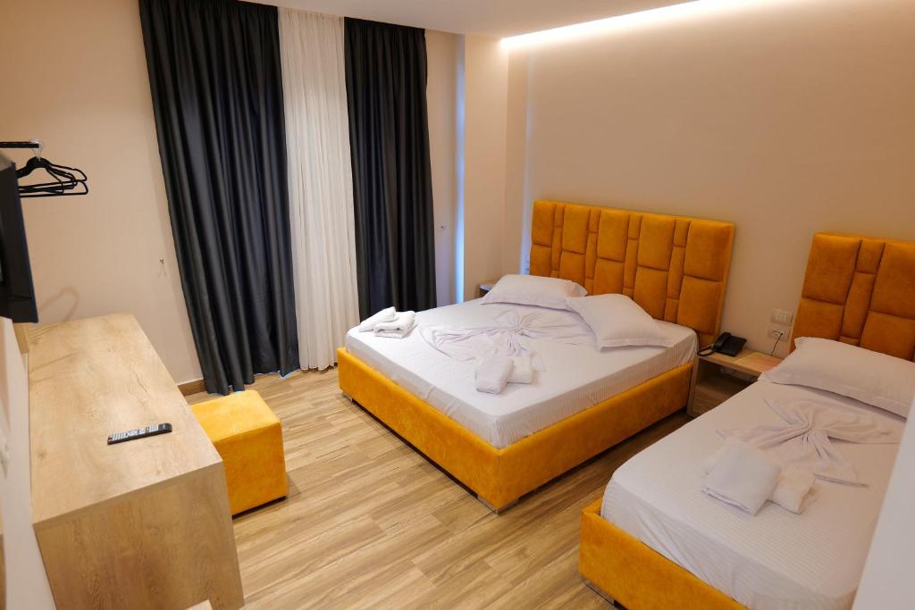a hotel room with two beds with towels on them at Hotel Alexander in Ksamil